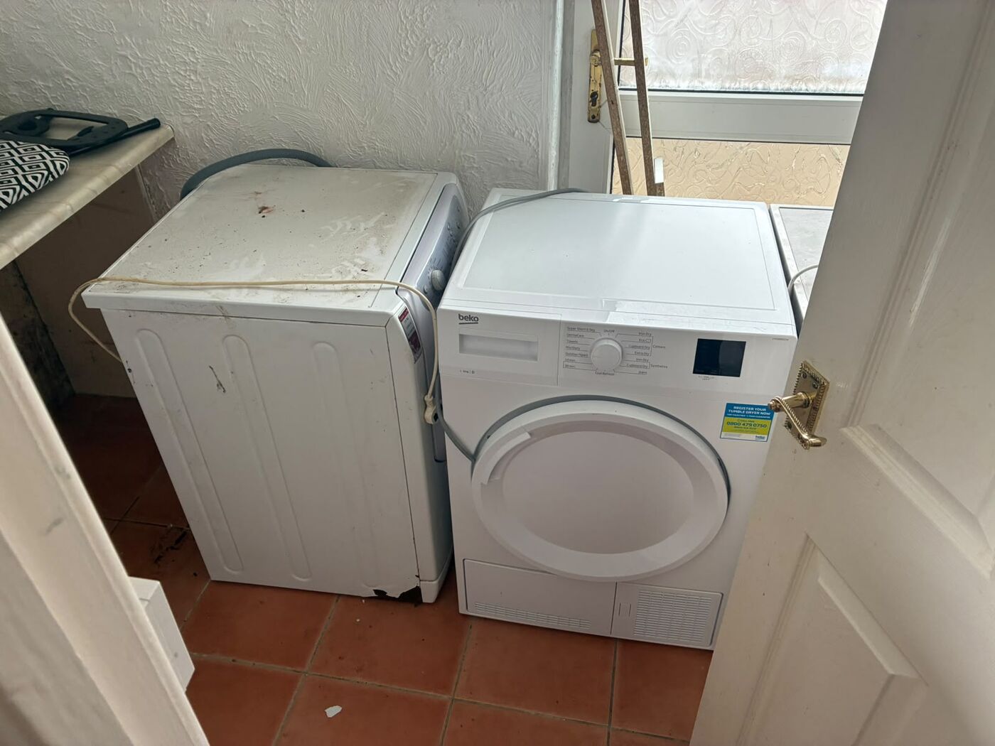 Washing machine and tumble dryer in place in a utility room before removal
