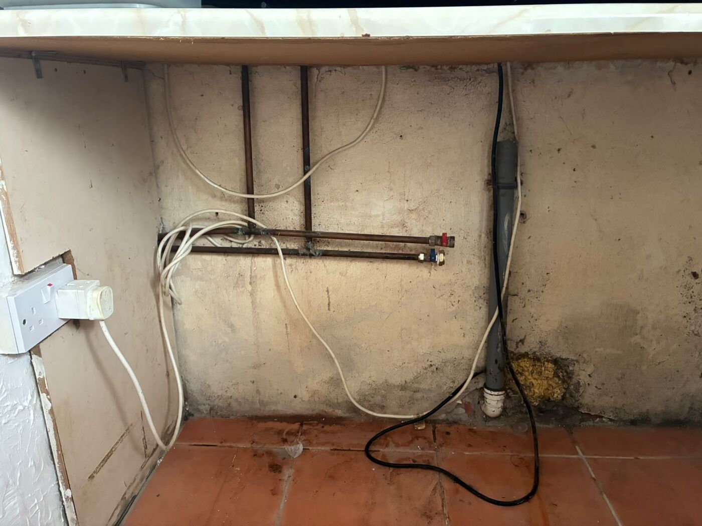 Copper appliance supply pipe work and capped connections on a utility wall