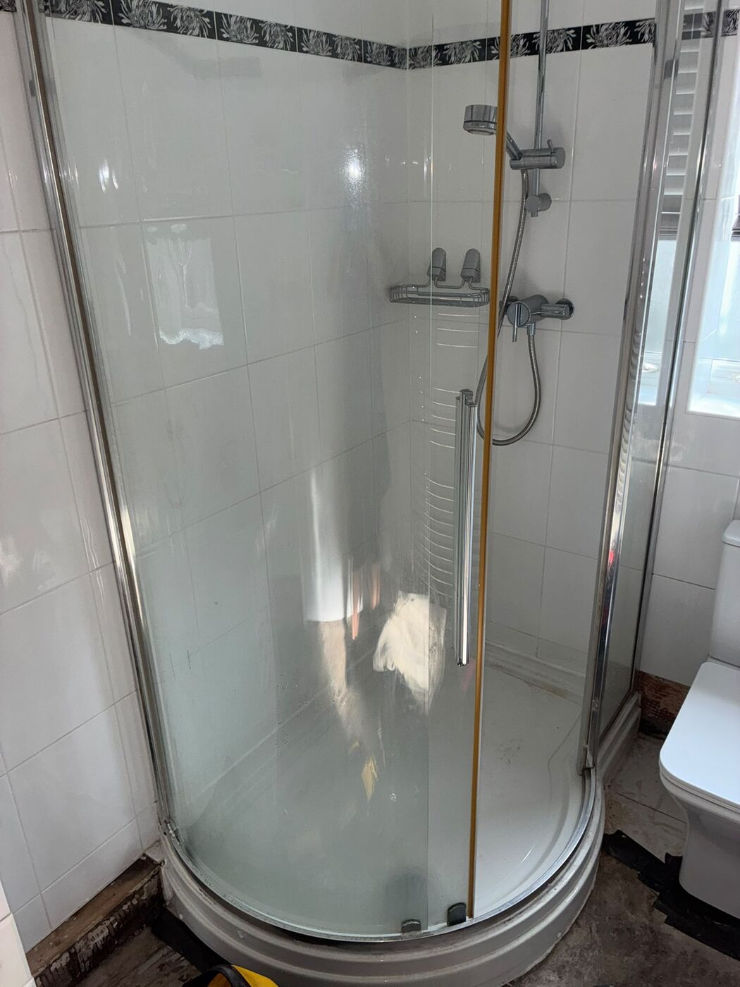 Existing quadrant shower enclosure and toilet before removal