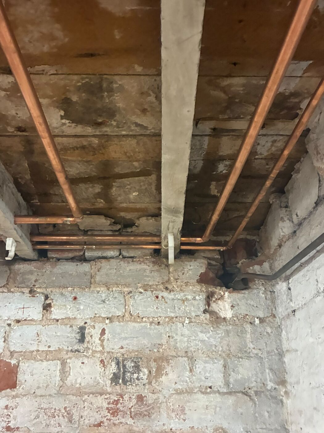 Copper flow and return pipe work run neatly through floor joists on a PureFlo job