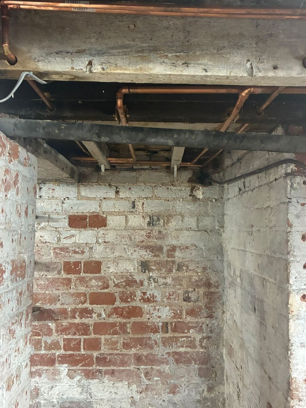 Copper pipe work and fittings routed through joists in a cellar ceiling