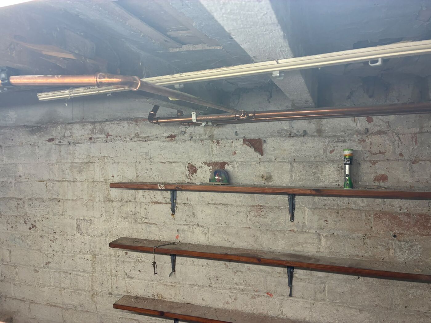 Copper pipe work along a brick wall with bracket supports in place