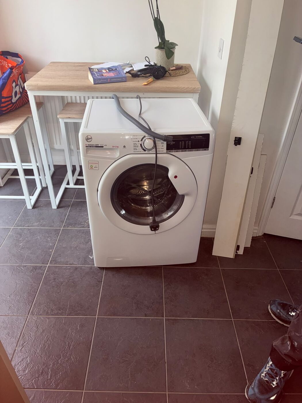 Washing machine plumbed in place in a kitchen before removal